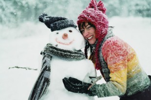 Portrait of a Young Woman in the Snow Next to a Snowman