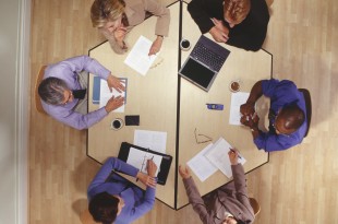 Group of businesspeople having business meeting in office, overhead view