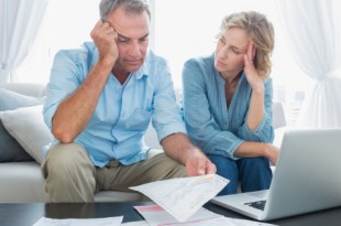 Worried couple using their laptop to pay their bills