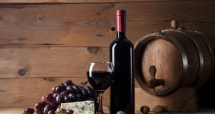 Red wine with blue cheese and ealnuts on wooden background