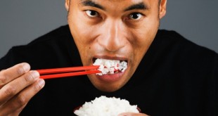 Asian man eating rice with chopsticks