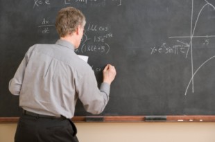 High School Teacher Writing Equation on Chalkboard